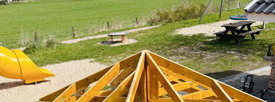 Neue überdachte Sitzgelegenheit im Bau & blühende Beete