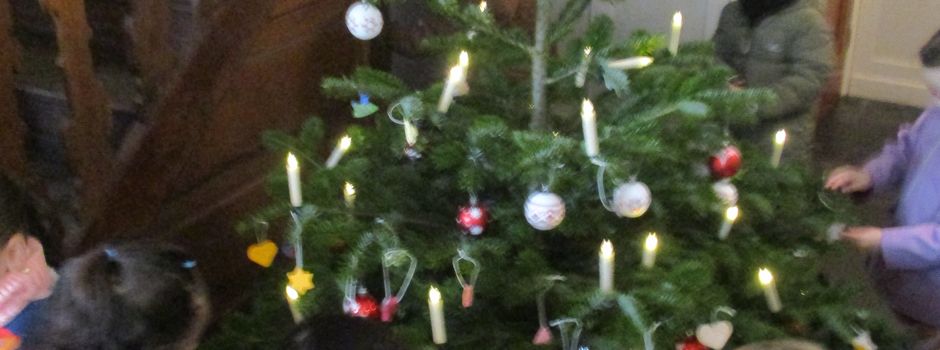 Kinder schmücken Weihnachtsbaum im Rathaus